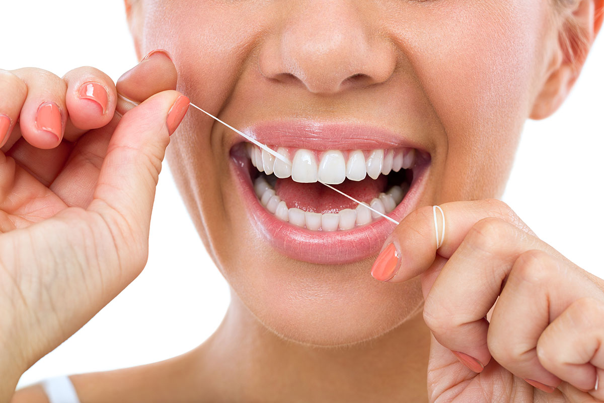 woman flossing to enjoy the benefits of flossing daily